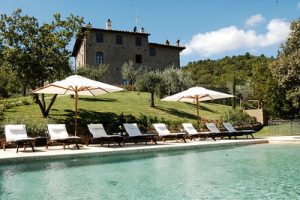 Chairs and umbrellas lined up by a pool in Tuscany, Italy