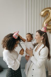 Two mothers celebrating their daughter's second birthday.
