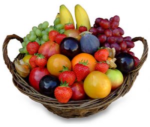 Fruit basket with grapes, bananas, plums, strawberries, apples, kumquats and oranges.