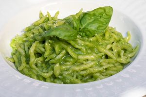 Pesto pasta with basil on top.