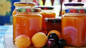 Jars of jam surrounded by fruit