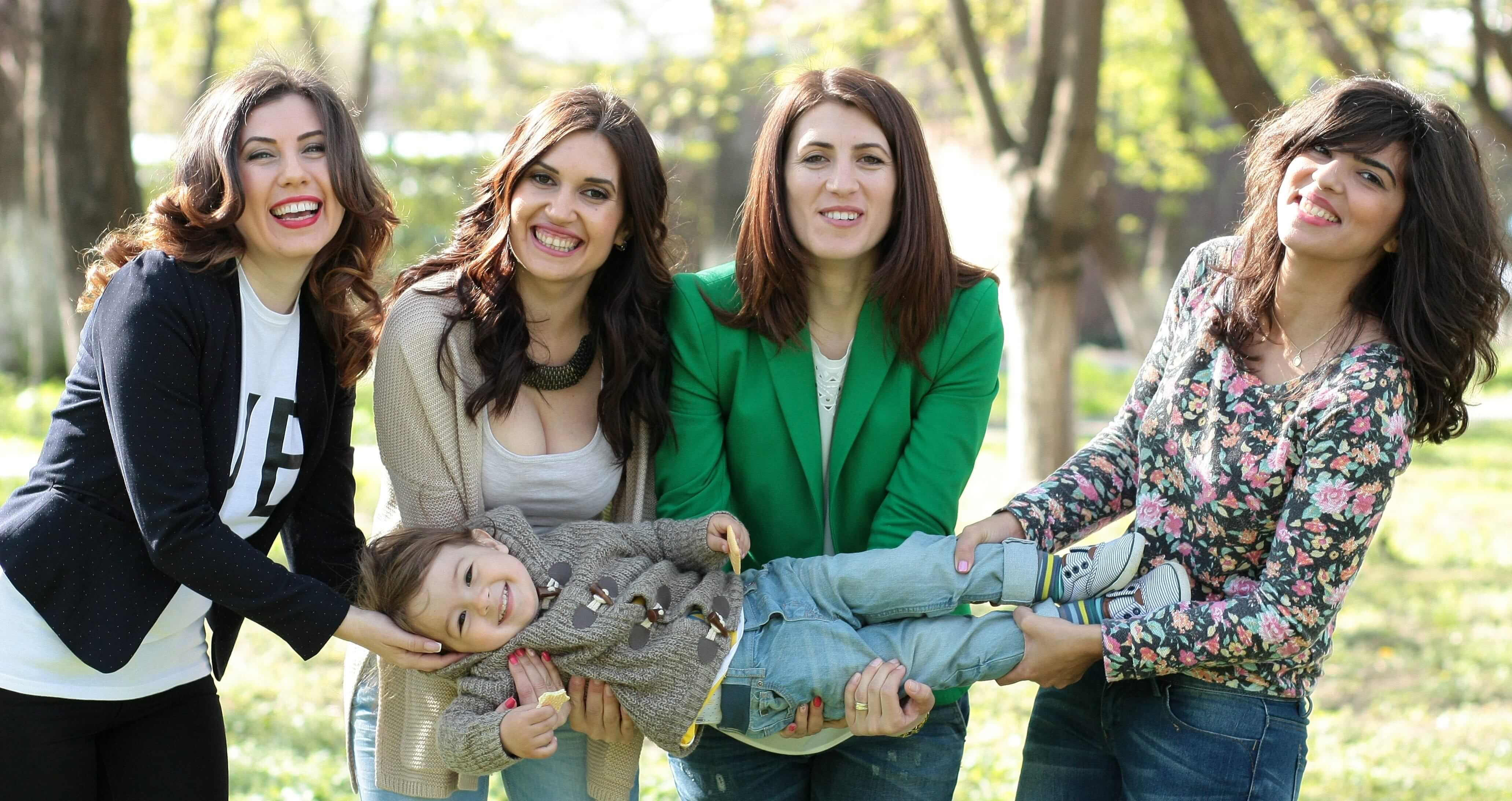 Four women holding a smiling child