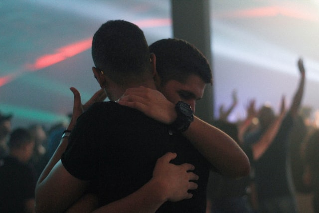 Two men hugging each other during a concert