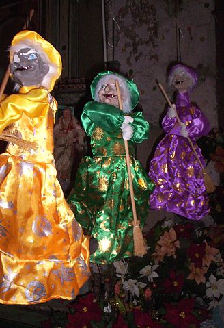 Three Befane dolls with yellow, green, and purple dresses