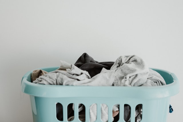 A light blue basket full of dirty clothes