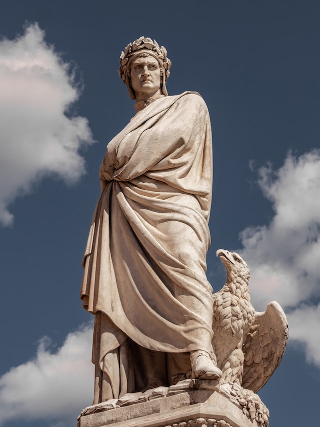 A statue of Dante Alighieri with a bird on his arm