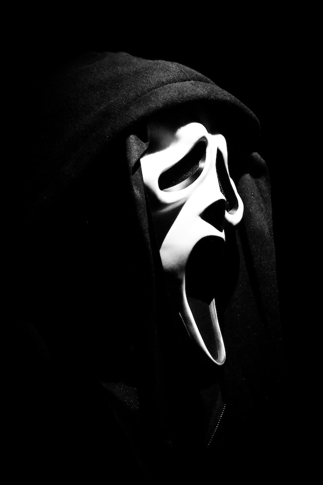 A scary white mask on a dark background