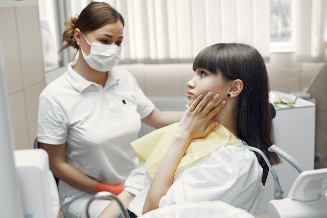 A girl at the dentist with toothache