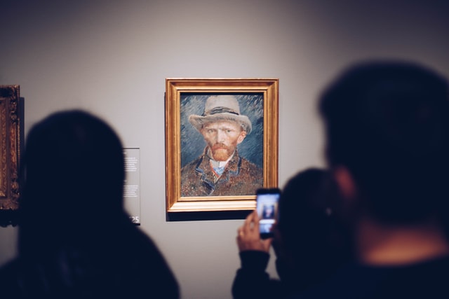 Person taking picture of a Van Gogh painting in a museum