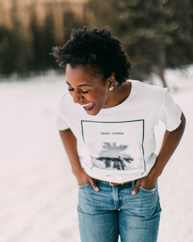 Black woman in white t-shirt laughing