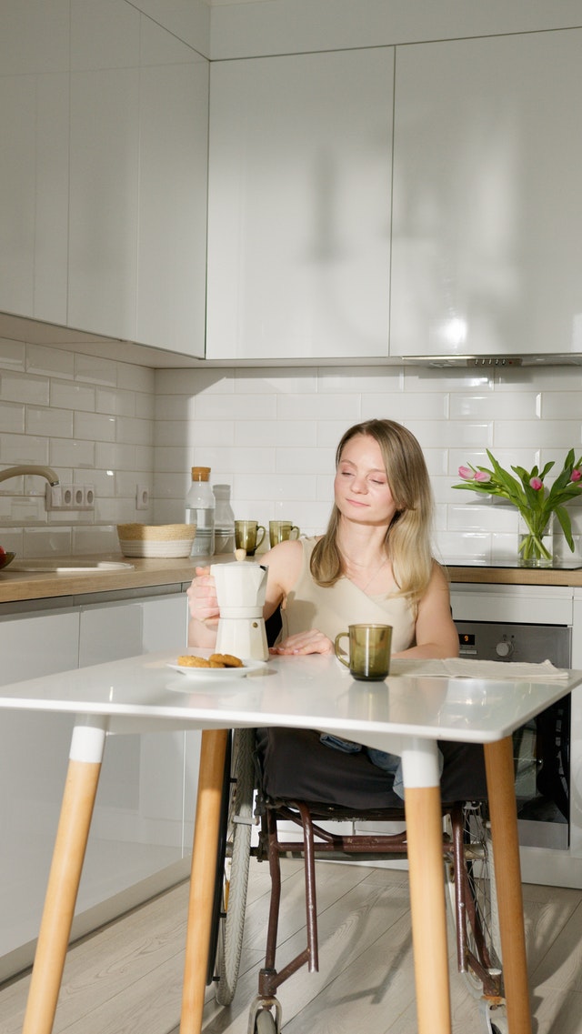 Person about to pour coffee from caffettiera into mug