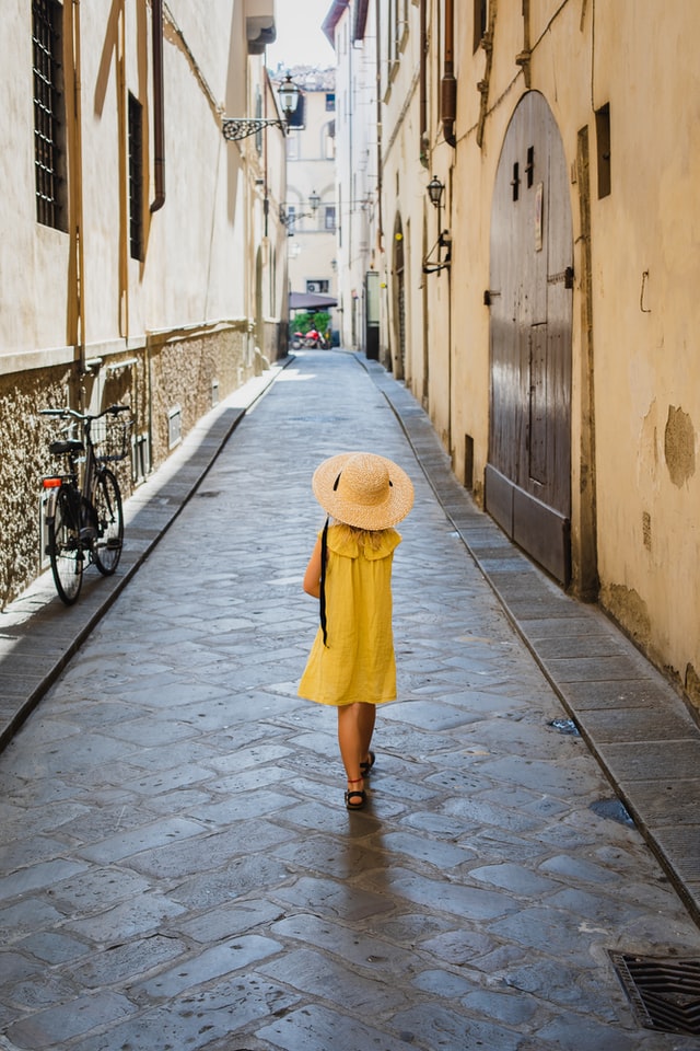 Person walking down the street wearing a sunhat and sundress