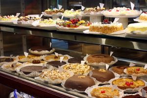 Store display with many cakes and tarts.