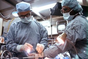 Two doctors operating on a person.