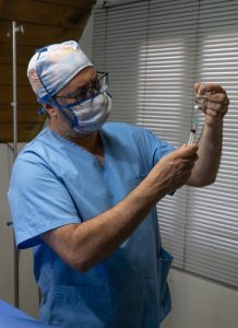 Nurse filling a syringe.