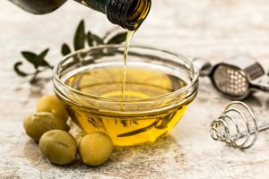 Olives next to a bowl of olive oil