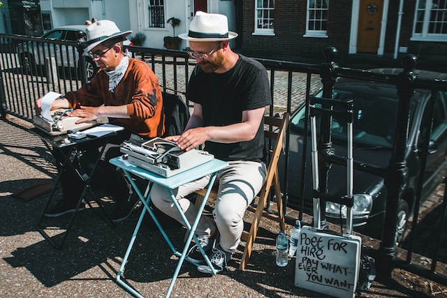 Two men writing poems on the street