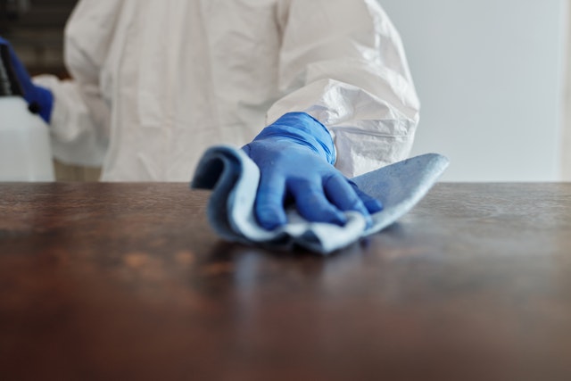 Person wiping down a table with a cloth