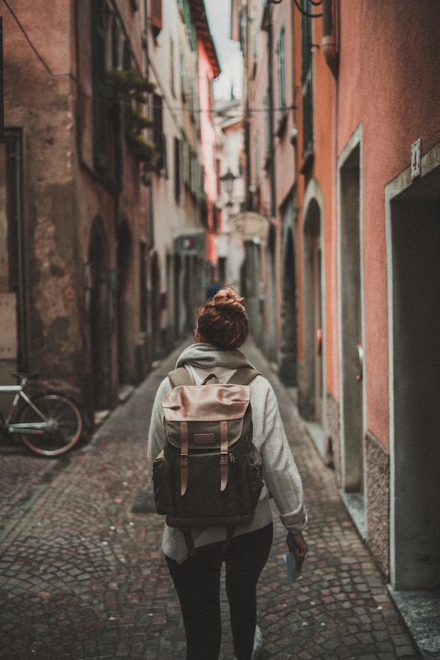 Woman walking on street surrounded by buildings