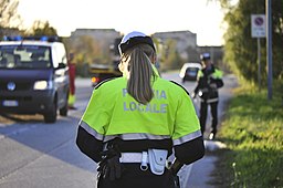 Person with their back turned in police uniform that says "Polizia Locale".