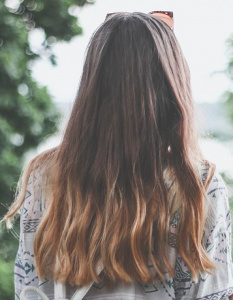 Person with long, wavy, hair with brown-blonde ombre