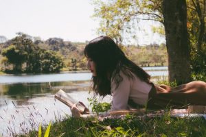 Person reading by a lake