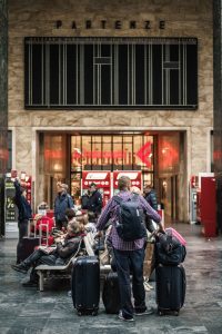 People with luggage entering a station